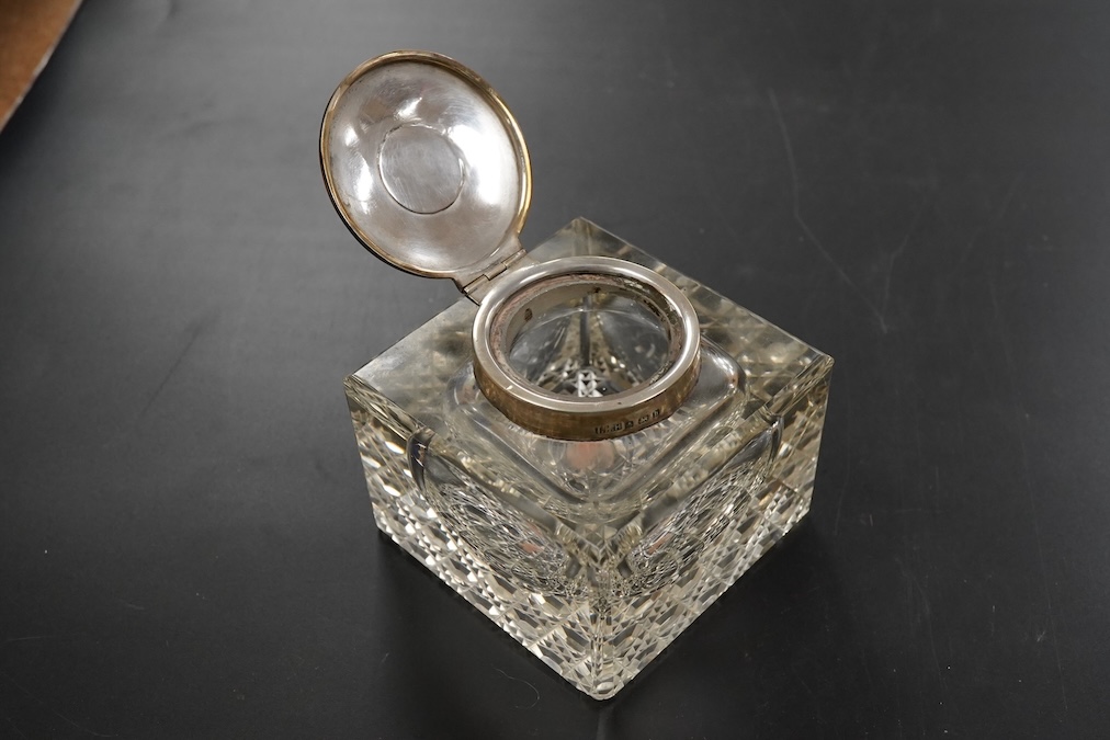 An Edwardian silver mounted clear glass inkwell, Birmingham, 1907, T Hazelwood & Co Ltd, square with hobnail cut base, the hinged mount with bee finial height 8.5cm